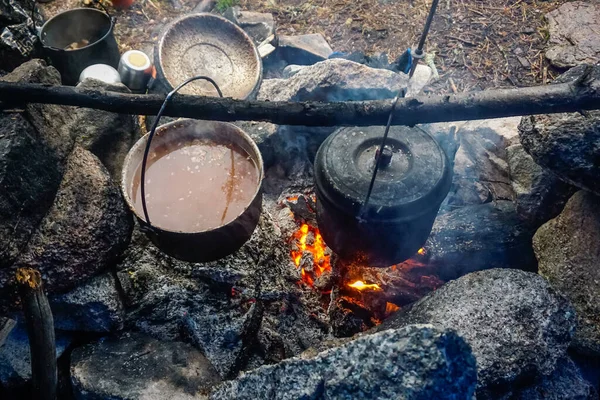 Ergaki 'deki Tayga' da ateşte tencerede yemek pişirmek.