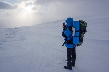 Avachinsky Geçidi 'ndeki yürüyüşçü ve kışın Kamçatka' daki volkanlar.