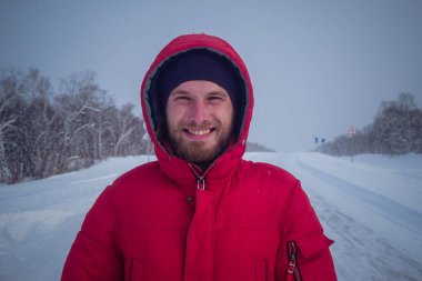 Rusya 'daki Kamçatka yarımadasında kışın karlı yoldaki adam.