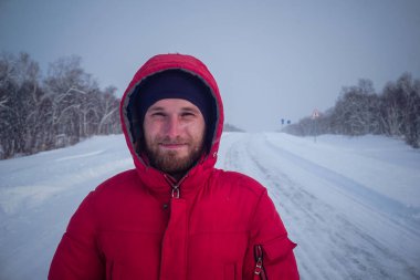 Rusya 'daki Kamçatka yarımadasında kışın karlı yoldaki adam.