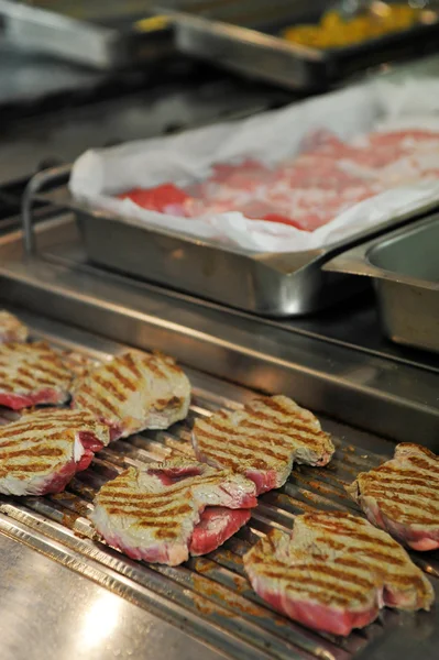 Etwas Fleisch auf dem Grill in einer Großküche — Stockfoto