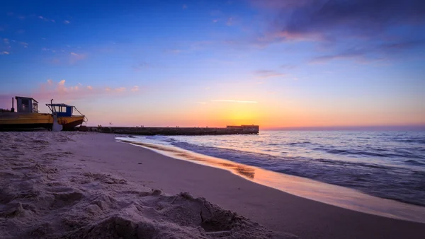 Pier a rybářská loď při západu slunce — Stock fotografie