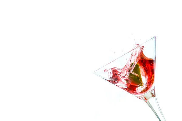 Red drink with lime falling into glass — Stock Photo, Image