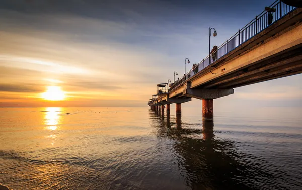 Sunset and pier in Miedzyzdroje — Stock Photo, Image