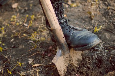 Asker botu ve süngülü kürek giymiş bir adamın bacağı.