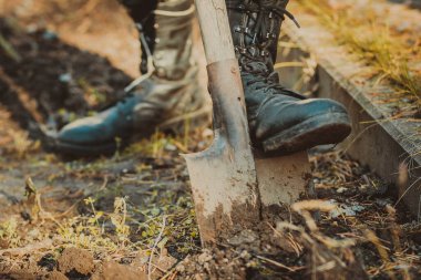 Asker botu ve süngülü kürek giymiş bir adamın bacağı.