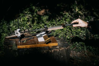 Klasik mutfak bıçağı bileme makinesi ve genç bir ustanın eli.