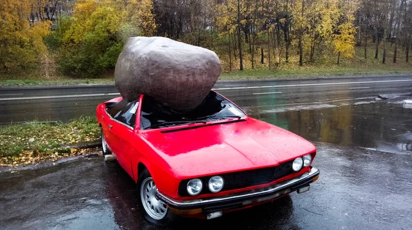 崩壊した車の屋根の上に巨大な岩 — ストック写真