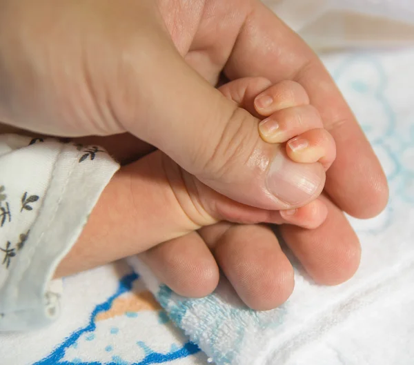 Nyfött barn hand på en manlig hand — Stockfoto