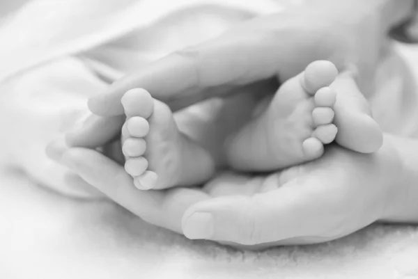 Νεογέννητο μωρό πόδια σε ένα γυναικείο χέρι — Φωτογραφία Αρχείου