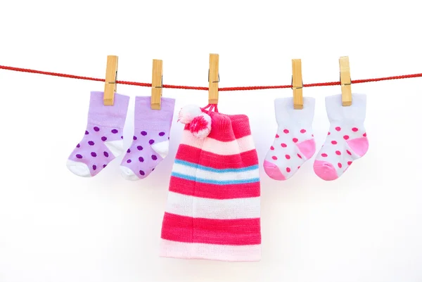 Dos pares de calcetines de bebé y una gorra colgando con el camino de recorte —  Fotos de Stock