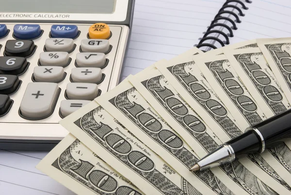 Calculadora y nosotros dólares en un cuaderno —  Fotos de Stock