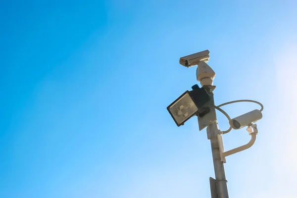 Beveiligingscamera op blauwe lucht achtergrond — Stockfoto