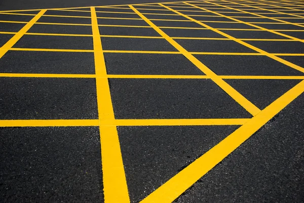 Cross yellow lines on blacktop — Stock Photo, Image