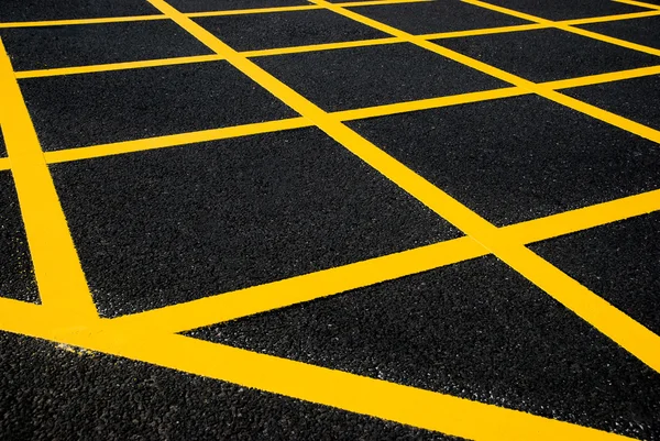 Cross yellow lines on blacktop — Stock Photo, Image