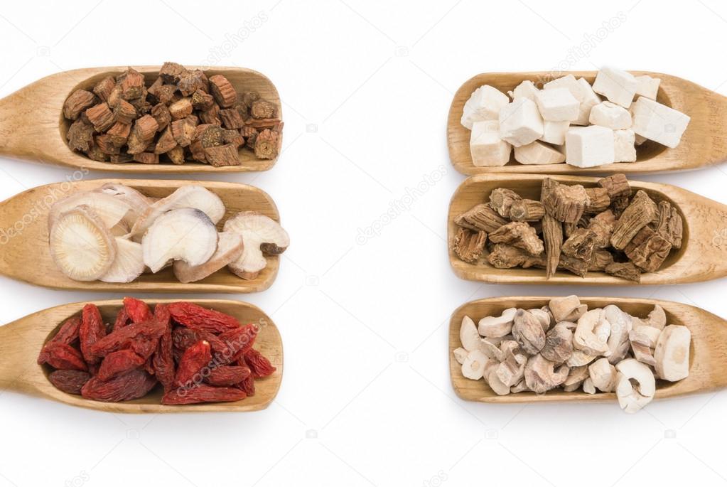 chinese herbs on wooden spoons, symmetric composition