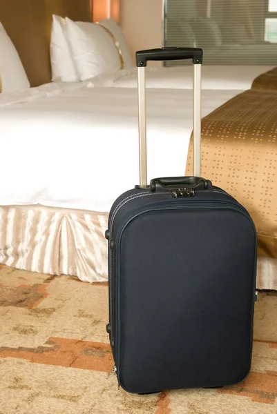 Kufr na posteli v hotelovém pokoji — Stock fotografie