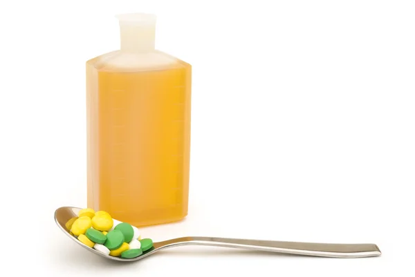 Spoonful of pills and medicine bottle with clipping path — Stock Photo, Image