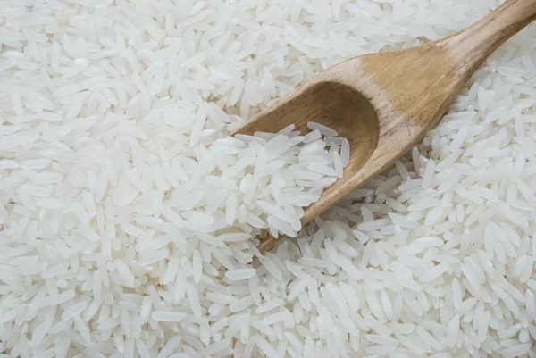 Arroz com uma colher de madeira — Fotografia de Stock