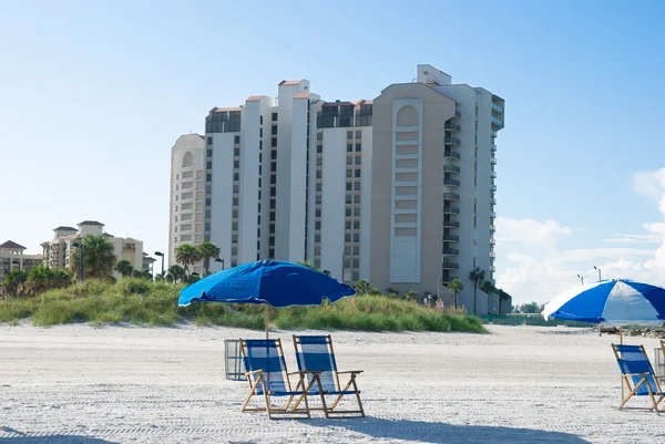 Stranden med solstol nära byggnader i en solig morgon — Stockfoto