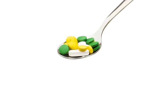 Pills in a steel spoon on white with clipping path — Stock Photo, Image