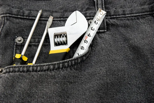 Herramientas en un bolsillo delantero de jean negro — Foto de Stock