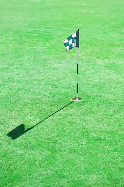 Bandeira de golfe em buraco no campo de golfe Verde — Fotografia de Stock