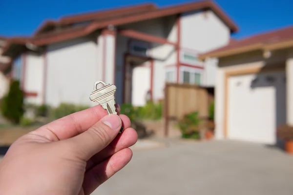 Handing key in a house background — Stock Photo, Image