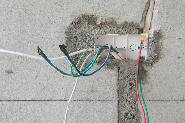 Close-up de uma tomada de cabo elétrico inacabado na parede — Fotografia de Stock