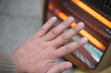 bir elektrikli ısıtıcı önünde el Isıtma