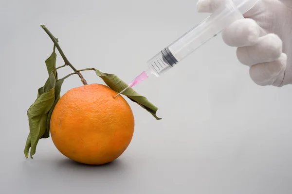 Dar uma injecção a uma laranja podre, conceito médico — Fotografia de Stock