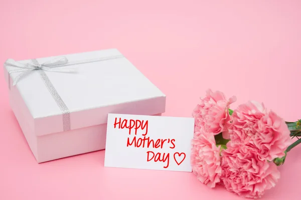 Cartão do dia da mãe feliz e caixa de presente e cravos rosa — Fotografia de Stock