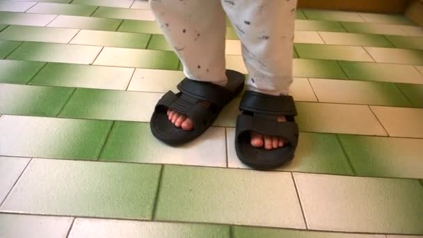 Μικρό αγόρι που φορώντας μεγάλες παντόφλες περπάτημα και γέλιο — Αρχείο Βίντεο