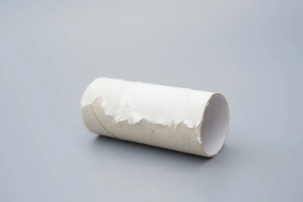 Toilet roll met het laatste stukje van weefsel op grijs — Stockfoto