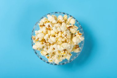 Mavi arka planda patlamış mısır kasesi