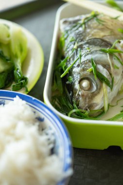 Buğulanmış balık, sebze ve pirinçten oluşan dik açılı fast food görüntüsü