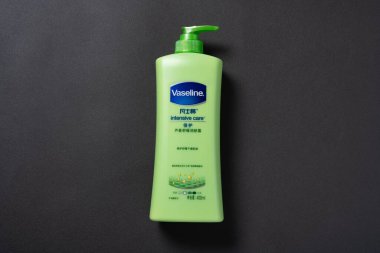 Zhongshan; Çin-14 Aralık 2020: siyah arka planda bir şişe vazelin yoğun bakım vücut kremi.