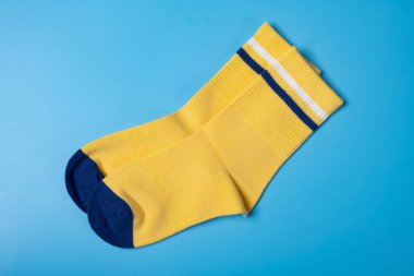 Mavi arka plandaki çocuk için bir çift sarı çorap