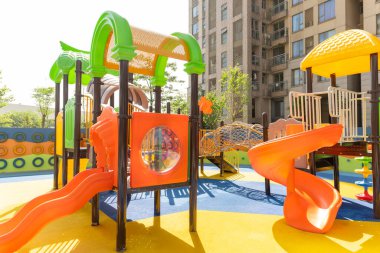 Güneşli bir sabahta konut binalarında çocuklar için oyun alanı