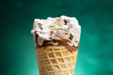 Vanilya ve çikolata aromalı dondurma külahı. Arkaplanda birkaç ısırık izi var.