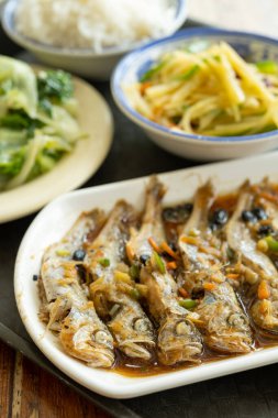 Haşlanmış küçük balıklar, lahana ve patates dilimleri ve pirinç dikey kompozisyonu.