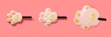 top view pink color bears paw shape popsicle melting process on pink background