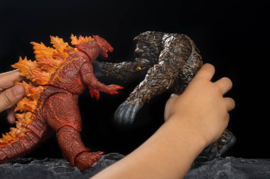 Zhongshan;China-May 7, 2021:kid playing with red Godzilla and King Kong at home.
