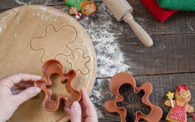 Klasik zencefilli bisküvi küçük adamlar şeklinde yapma süreci. Malzemeler ve figurines ahşap bir zemin üzerine natürmort. Üstten Görünüm.