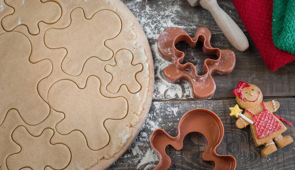 Klasik zencefilli bisküvi küçük adamlar şeklinde yapma süreci. Malzemeler ve figurines ahşap bir zemin üzerine natürmort. Üstten Görünüm.