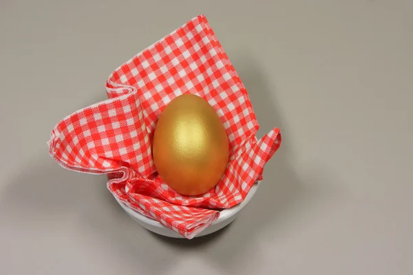 Golden egg in a patterned napkin — Stock Photo, Image