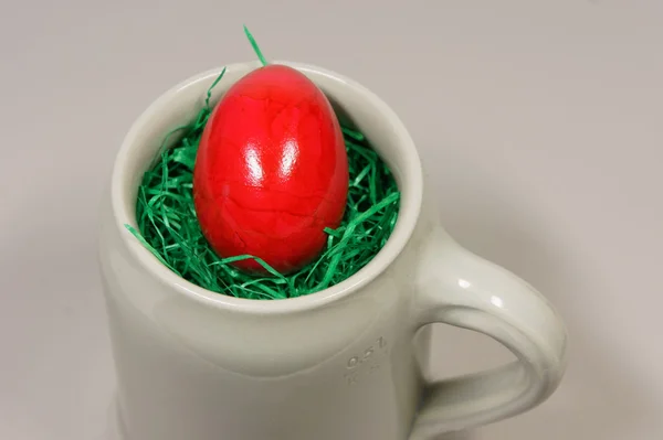 Red egg in a beer Bembel with green grass — Stock Photo, Image