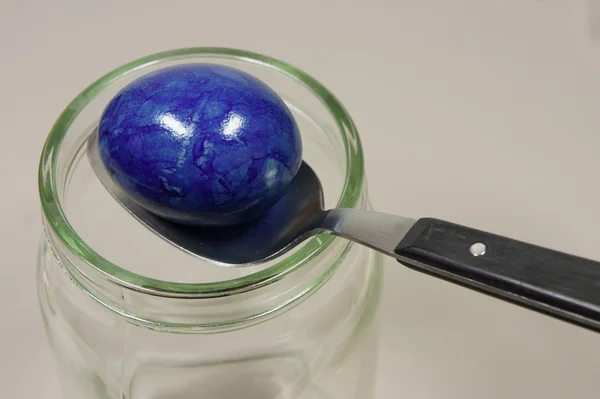 Красочное яйцо с ложкой на стекле — стоковое фото
