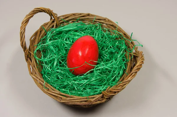 Red egg in a basket with green grass — Stock Photo, Image
