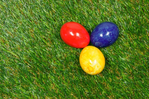 Красочные яйца лежат на синтетической траве — стоковое фото